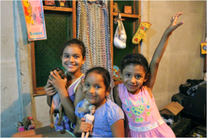 Priscilla, Rosita, and Jimena pose for a photo with their dolls and Roxy, the family’s puppy